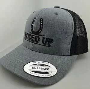 A grey and black hat with the words rodeo up on it.