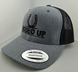 A grey and black hat with the words rodeo up on it.