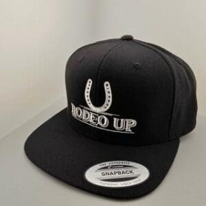 A black hat with the words rodeo up on it.